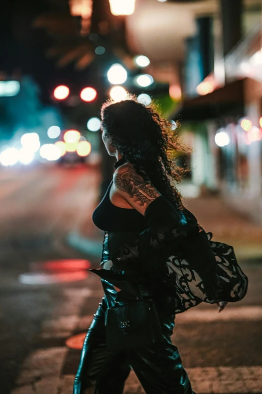 a woman on a cell phone on a city street at night