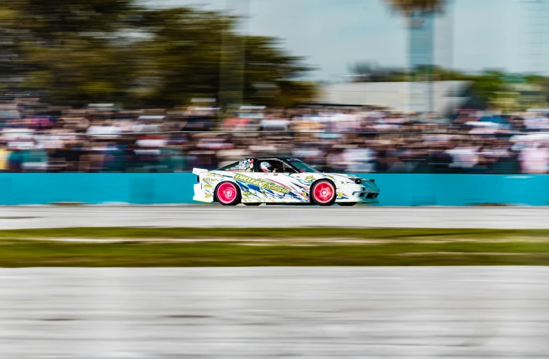 there is a racing car on a track and a crowd in the background