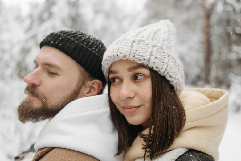 a young man and woman standing in the snow next to each other