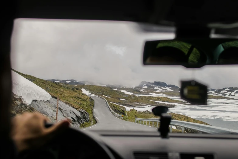 a view from inside of a car looking at a snow covered mountain