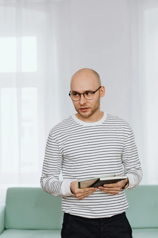 man in striped shirt holding cellphone looking at screen