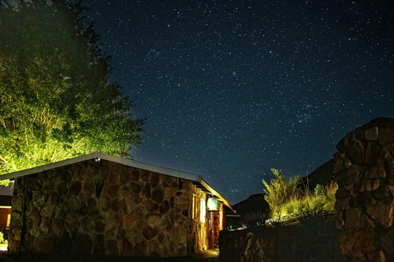 a night view of the house with trees and stars