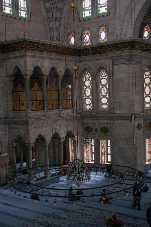 the interior of a big building with windows and people