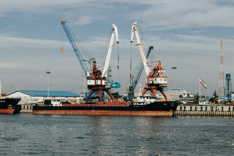 some large cranes and trucks in the water