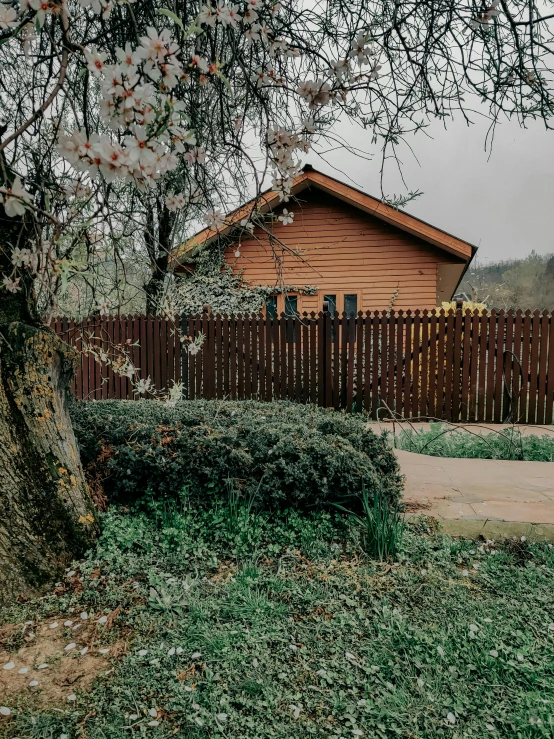 the side of a house surrounded by a tall wooden fence