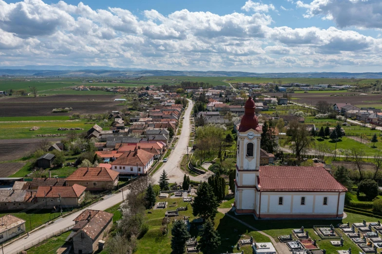 an aerial view of a small town with an older church and cemetery