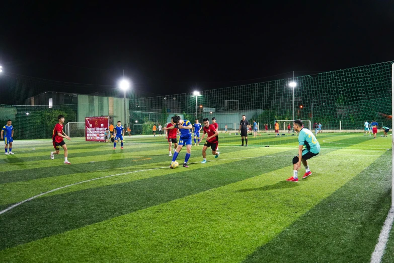 soccer players in red and blue and green on the field