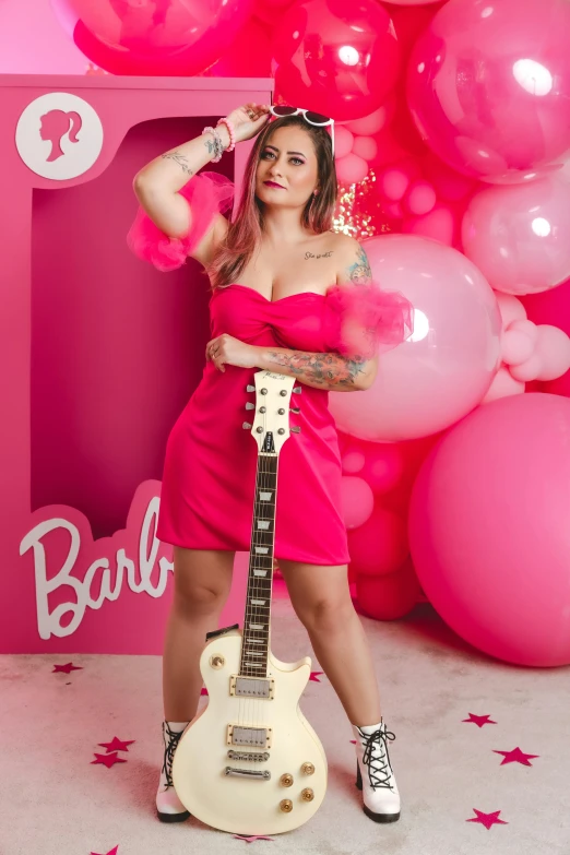 a woman poses with her guitar at an unveiling