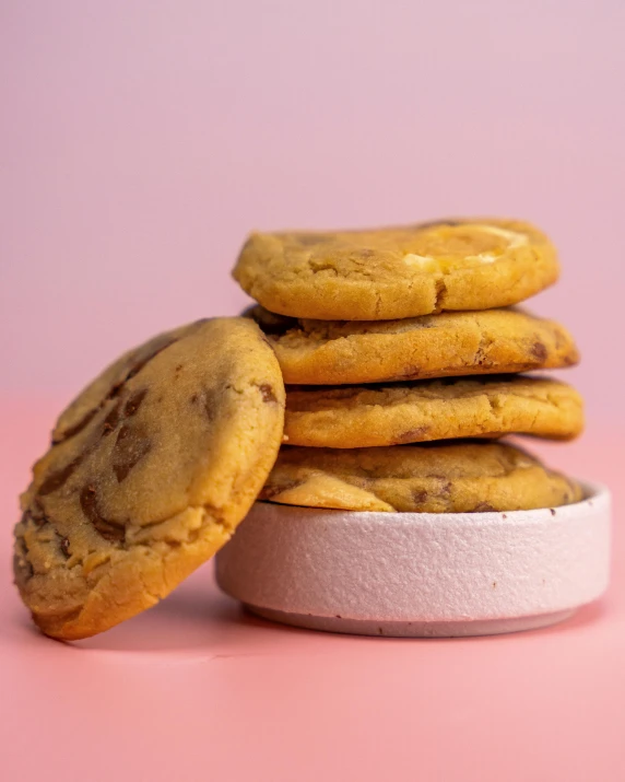 a pile of cookies sitting in front of a pink background