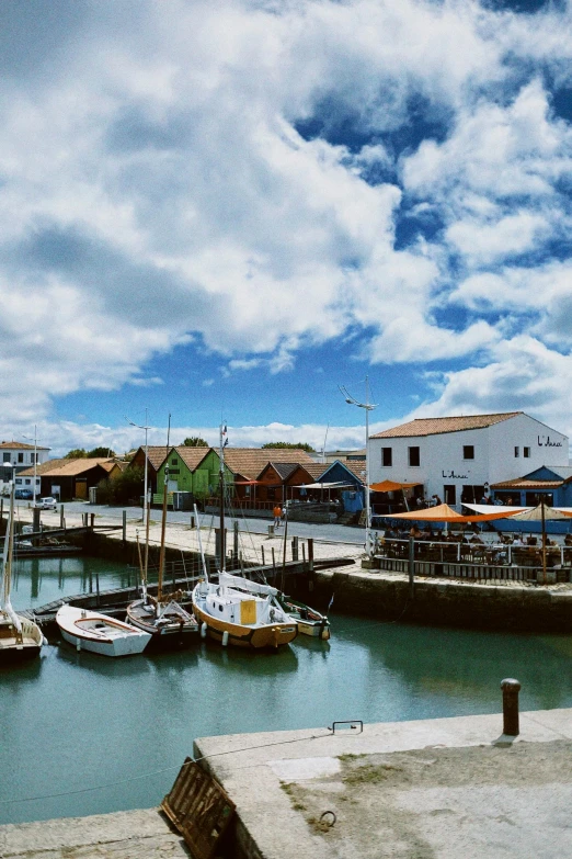 a bunch of boats parked by the dock on a cloudy day