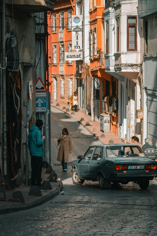 two people looking at a vehicle on an urban street