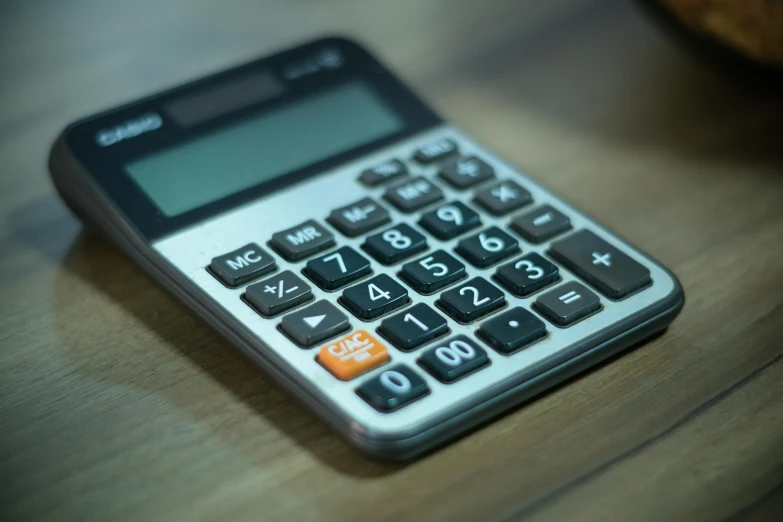 a calculator is sitting on the desk with no letters on it