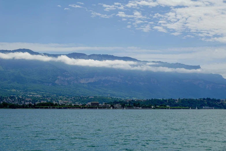 a picture of some water and mountains with clouds