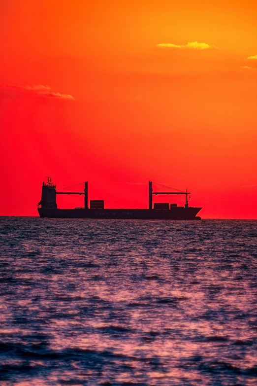 two ships floating in the ocean with sunset