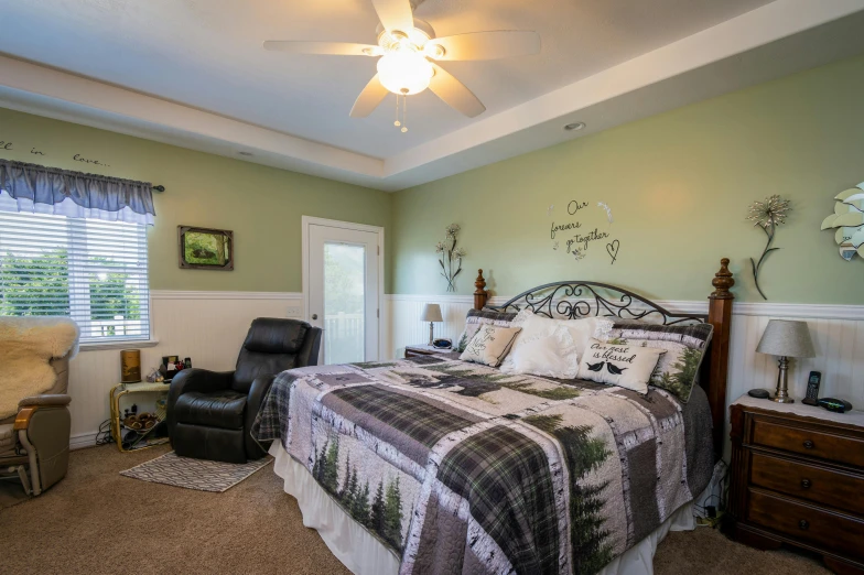 a green bedroom with a bed and a chair