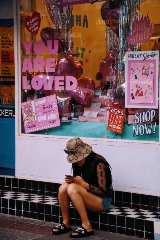 a woman sitting on the street holding her stomach