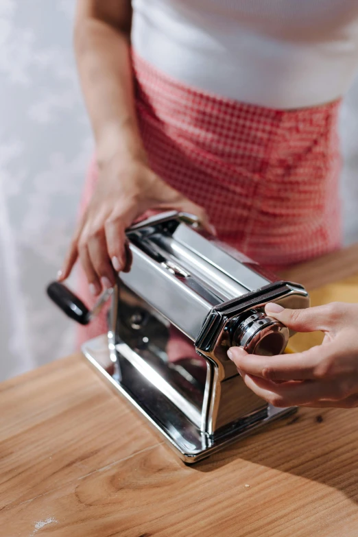 a person holding an item and pressing on on a toaster