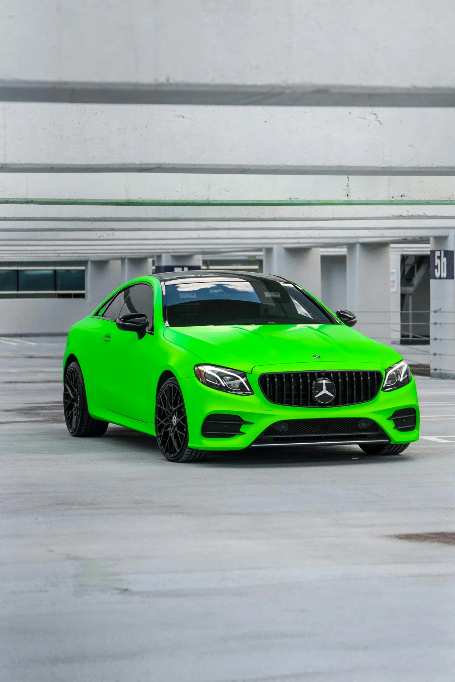 a green sports car in an parking lot