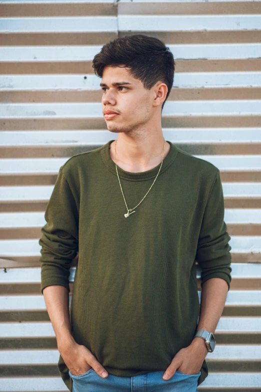 a young man in jeans standing in front of a building