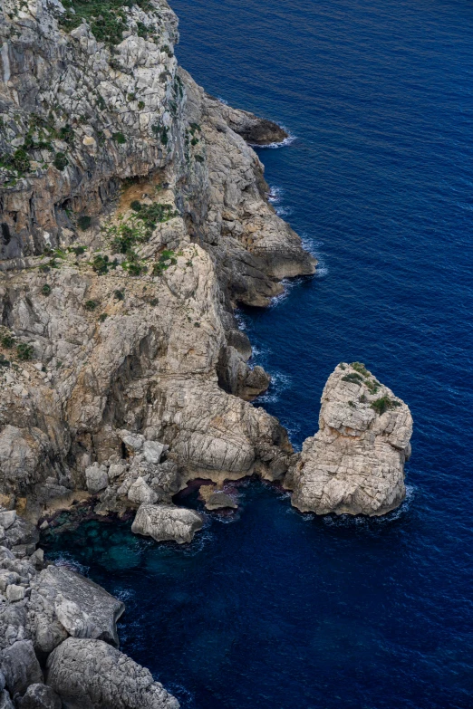 the top of a large cliff is in the blue water