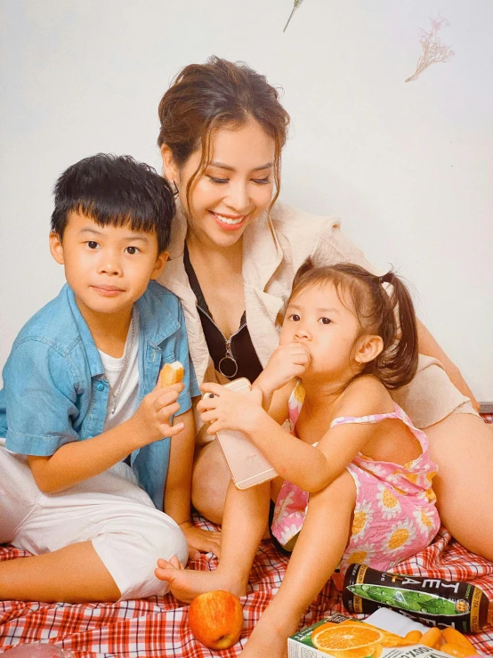 a mother with two small children sitting on the bed