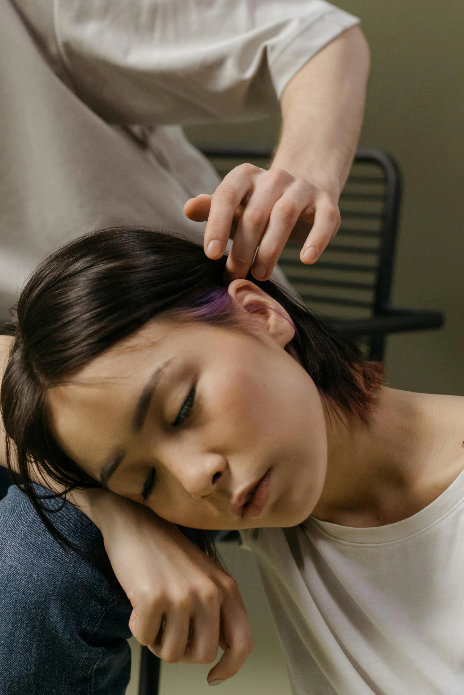 woman having her head placed on the back of her friend