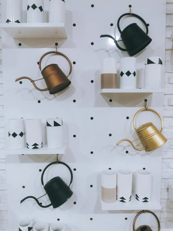 a wall display of toilet paper, cups, and a can on white shelves