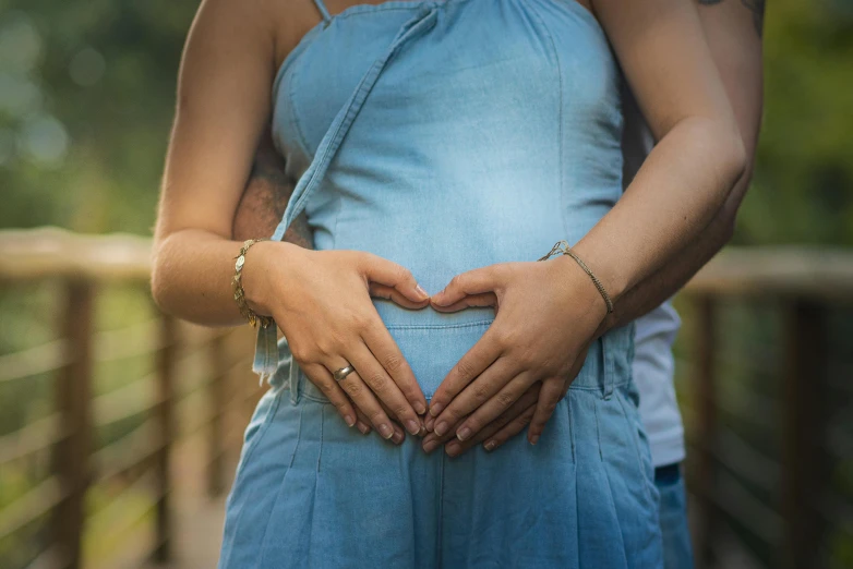 there is a pregnant woman holding her hands on the stomach