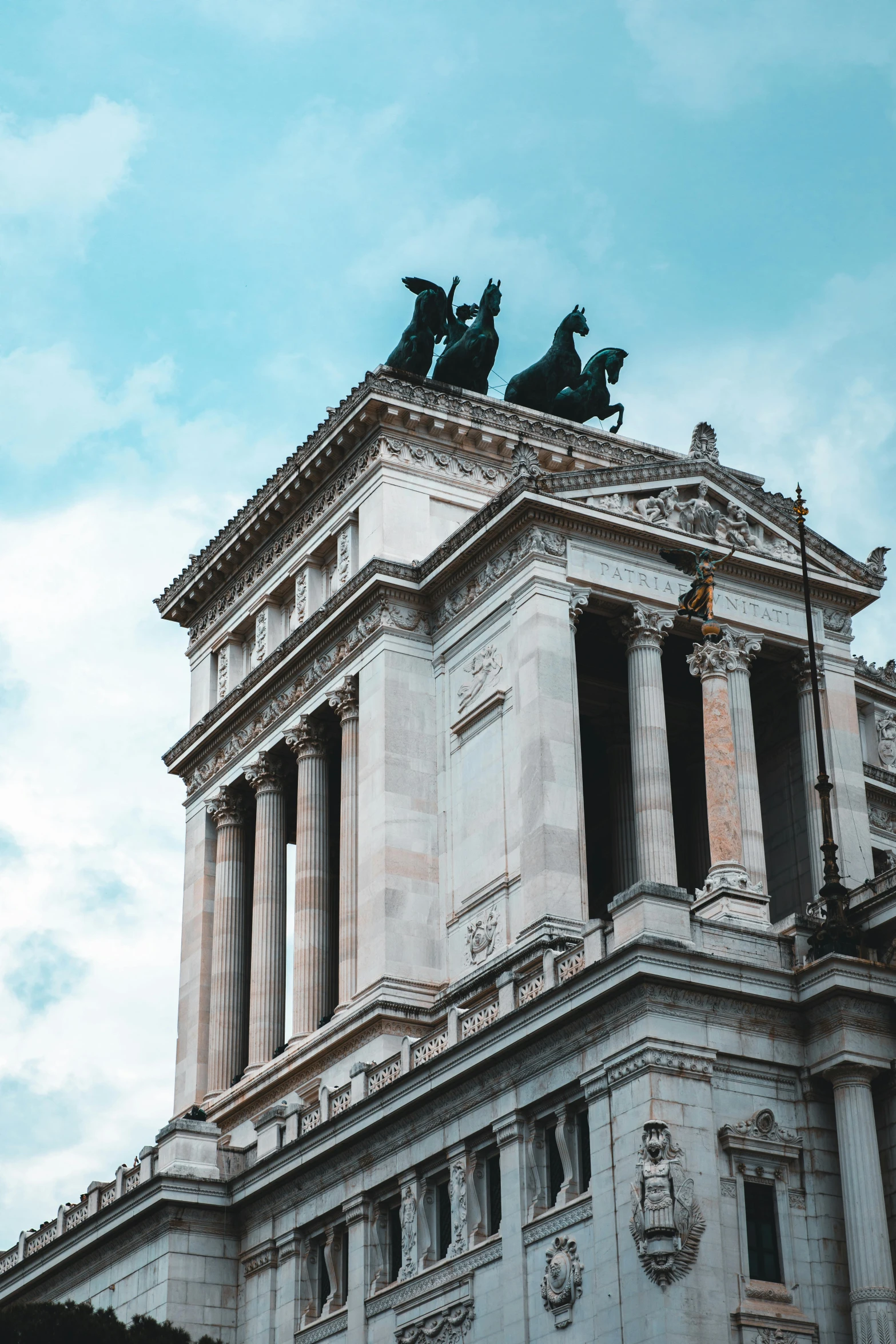 a tall building with statues atop it's top