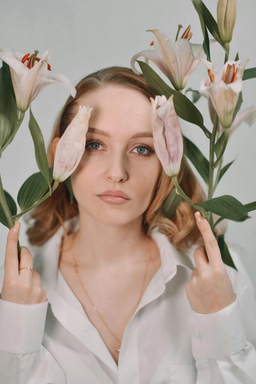 young woman making funny faces while holding flowers above her head