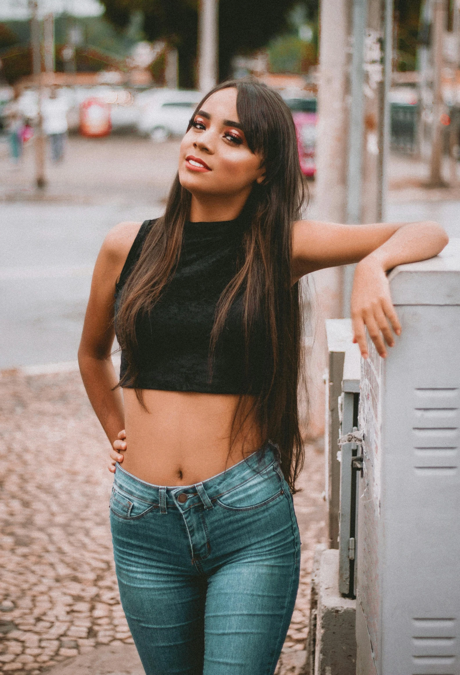 a pretty young woman leaning against a wall