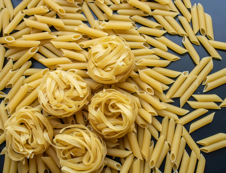 five pieces of pasta on a dark surface