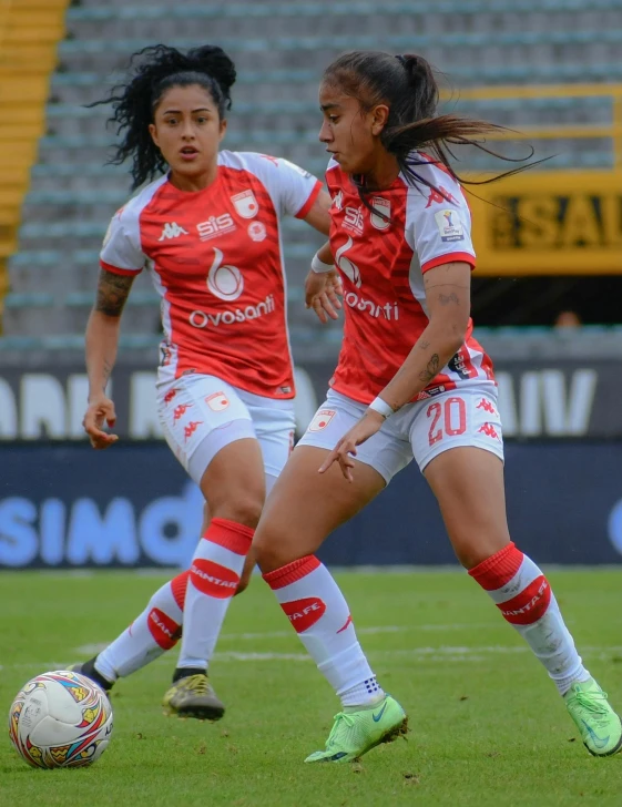 a couple of women are playing soccer on the field