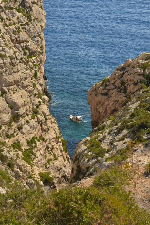 two boats are anchored to the shore and one is on water