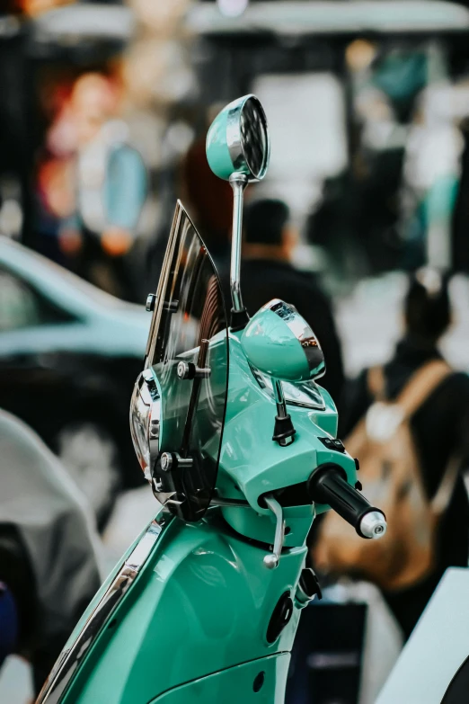 a turquoise green scooter with no passengers on the street