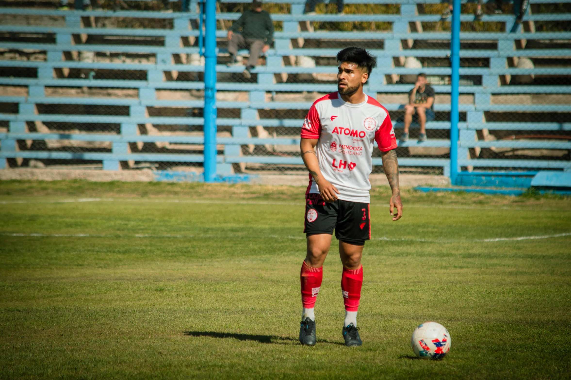 the soccer player is wearing a red and white shirt