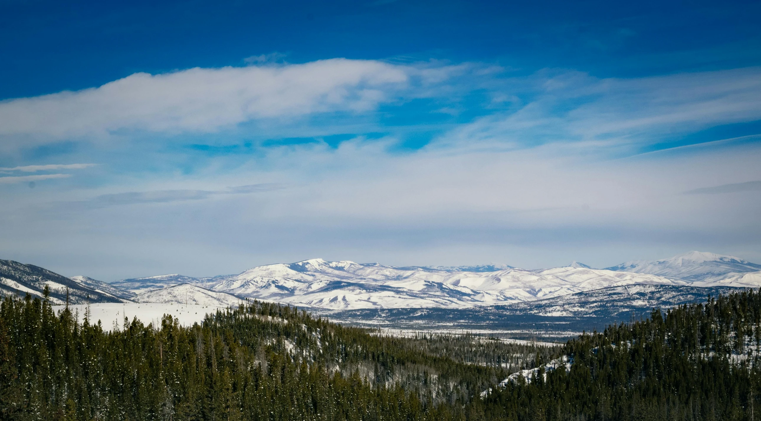 a mountain range with some snowy hills in the background