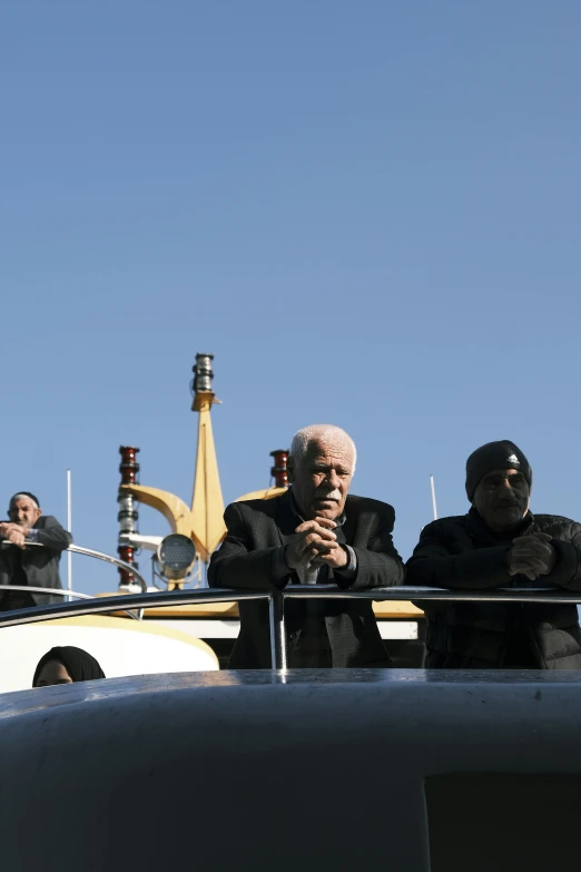 men in black outfits standing on the deck of a ship