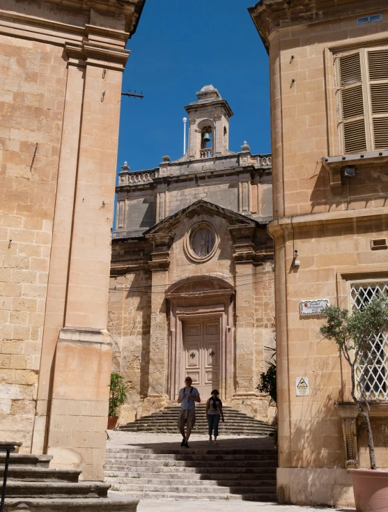 two people are walking down some steps near a church