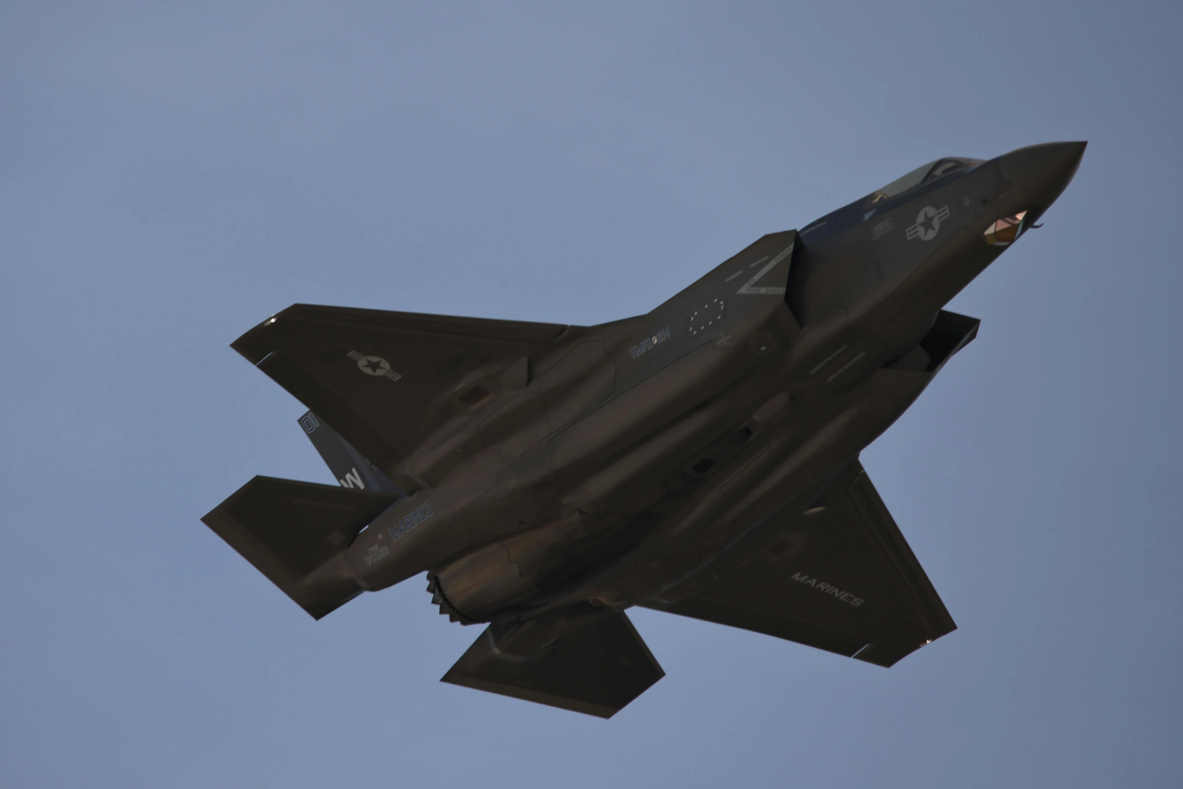 the military fighter jet flies high through the air