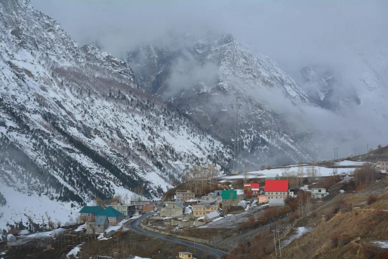 the snowy mountains are in a foggy mountain valley