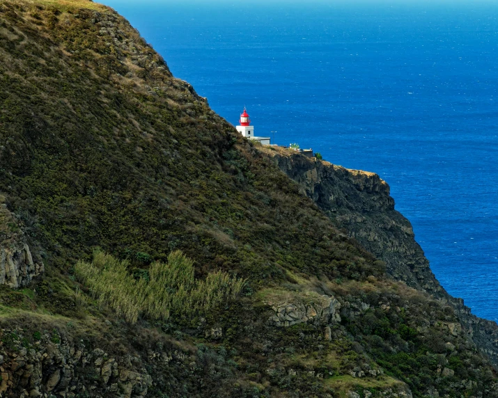 a light house sits on the edge of a cliff