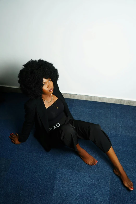 an african woman in a black dress and her long curly hair