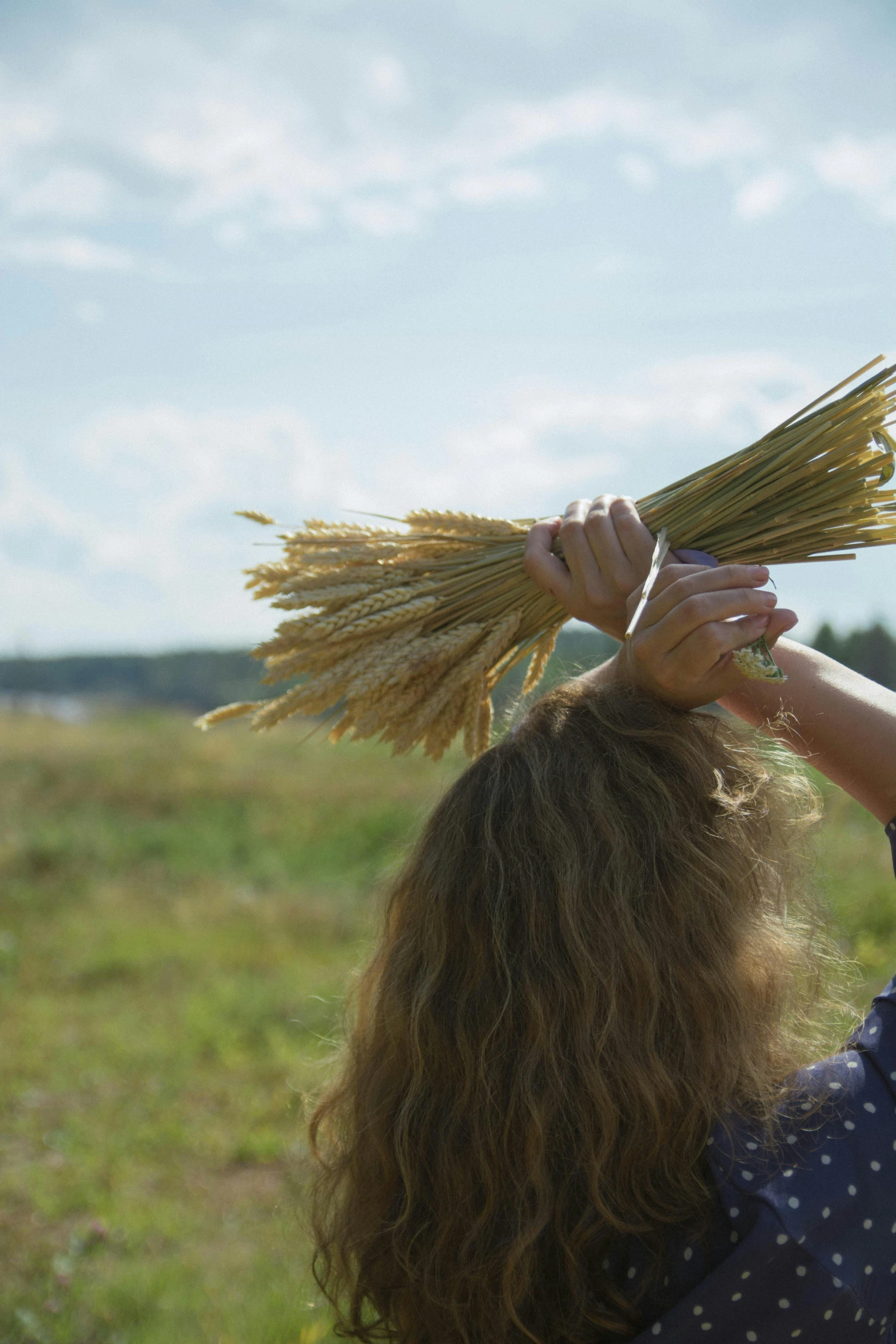 a woman is holding some stalks of wheat