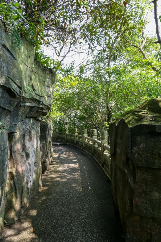 the path is between two large rocks, as well as trees