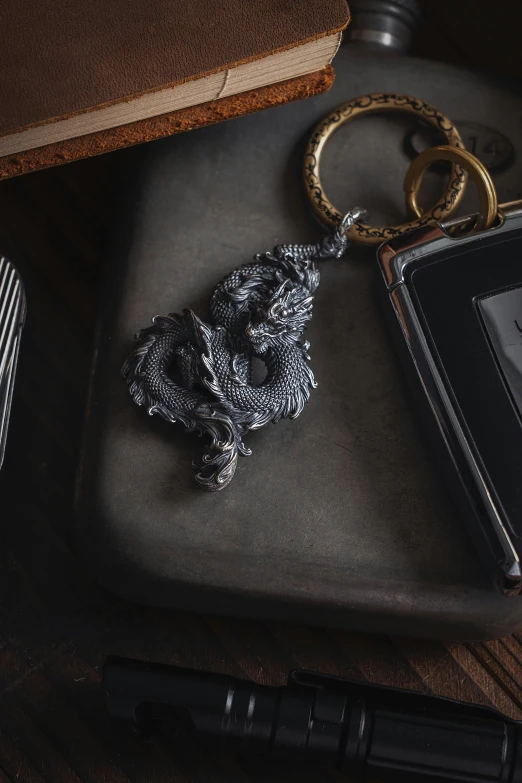 a close up of a key chain with a book on a table