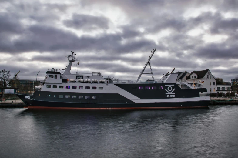 a large ship sits on the water in the harbor