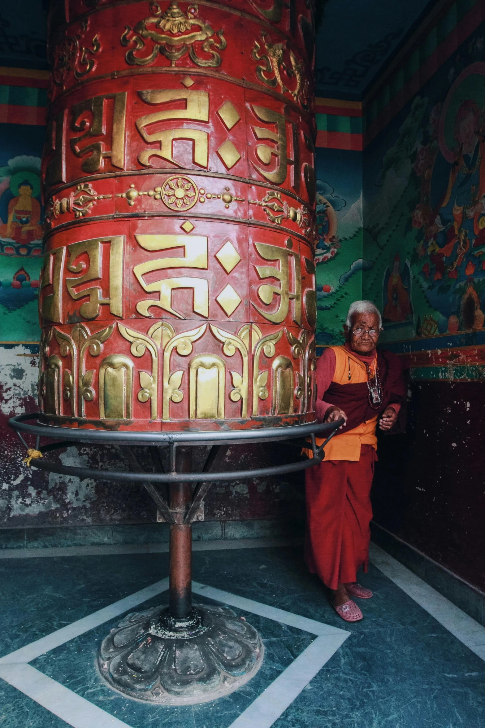 monk doing weaving for shrine sculpture on top of stand