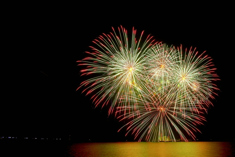 fireworks fill the night sky above water