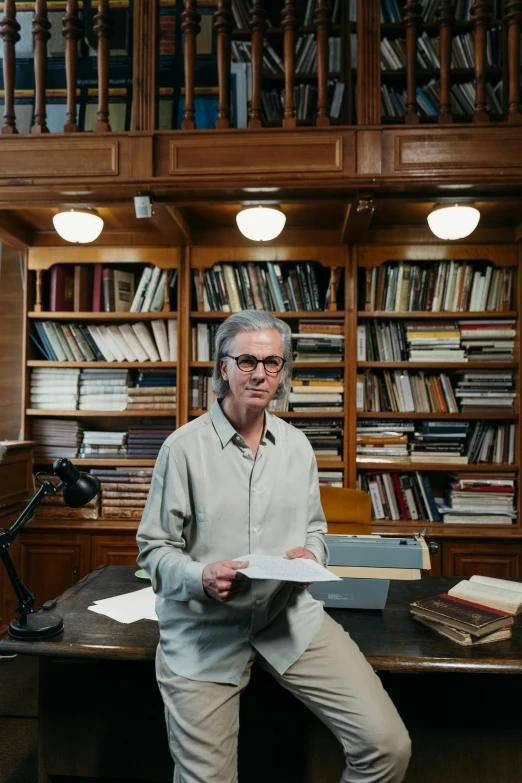 a man that is standing up and reading some papers
